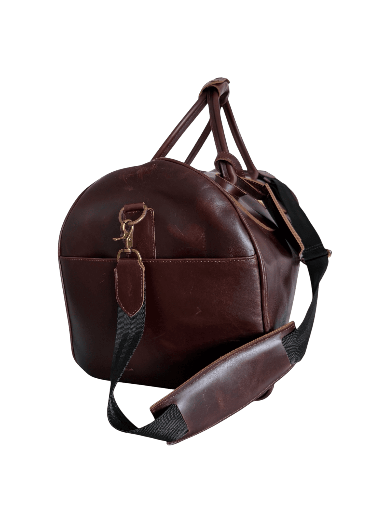 La Herencia Carryall in burgundy leather, left side studio view